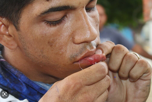 Migrantes en caravana se suturan labios para presionar a Migración de México