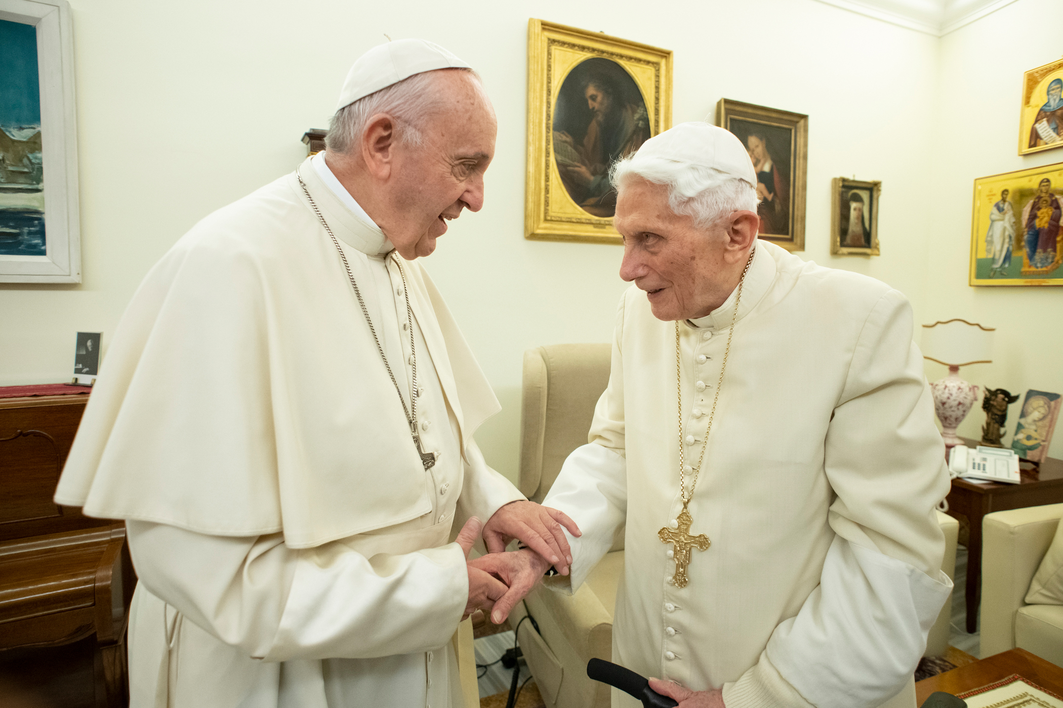Dos religiosos conversando en una habitación decorada