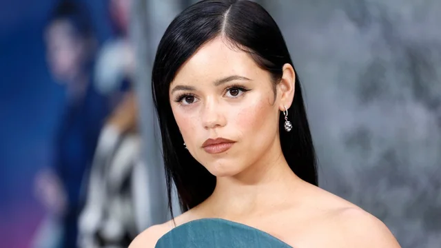 Mujer joven en alfombra roja, vestido elegante.