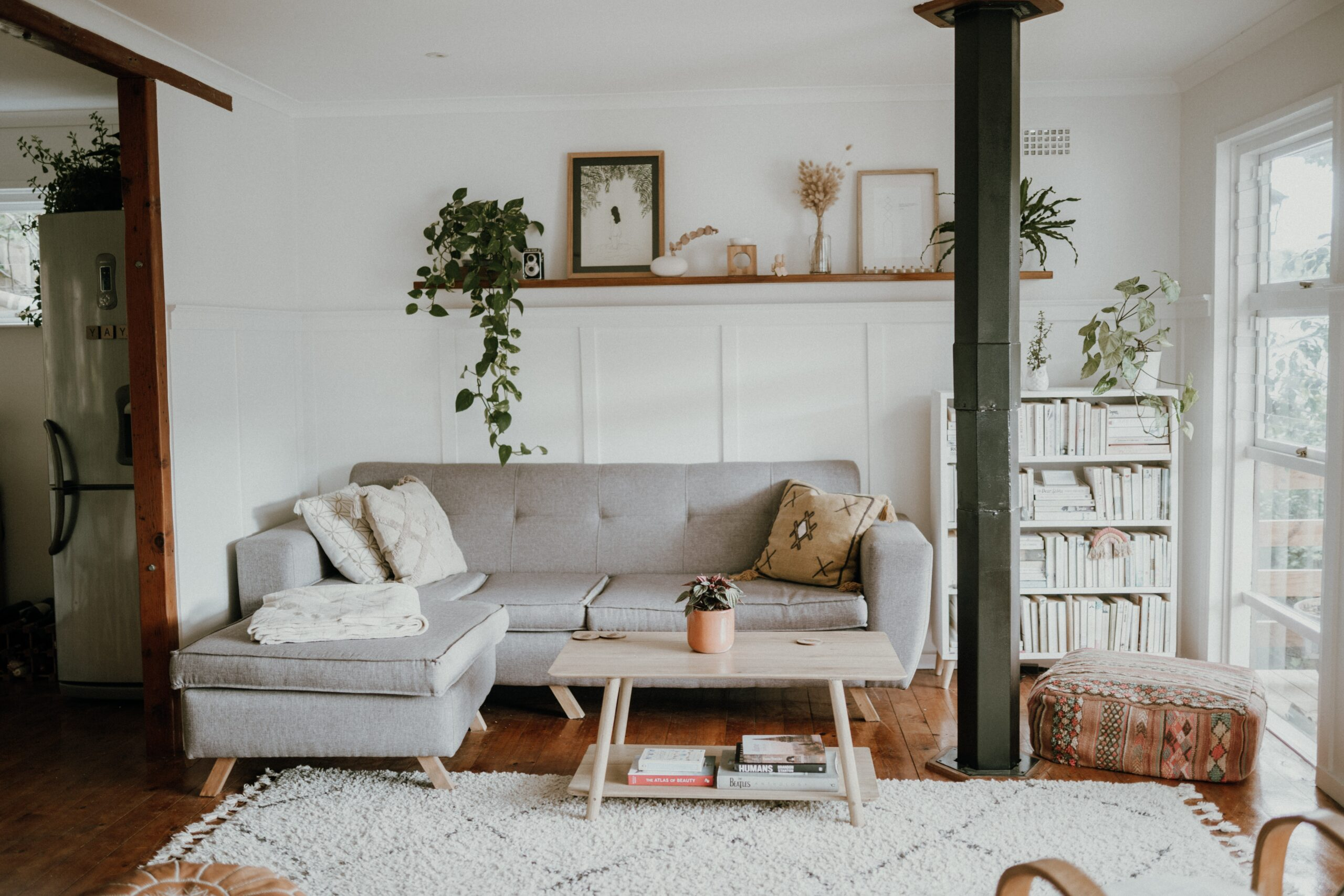 Sala luminosa con sofá gris y plantas decorativas