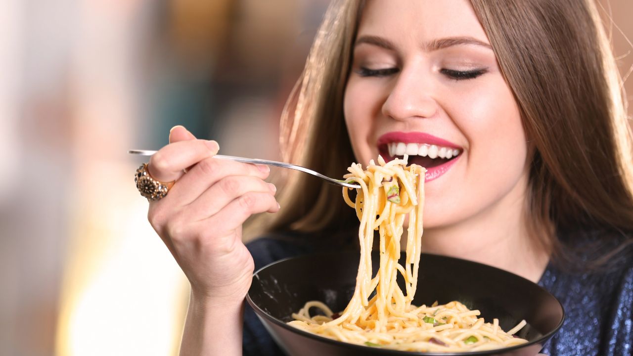 Mujer comiendo espaguetis con ganas