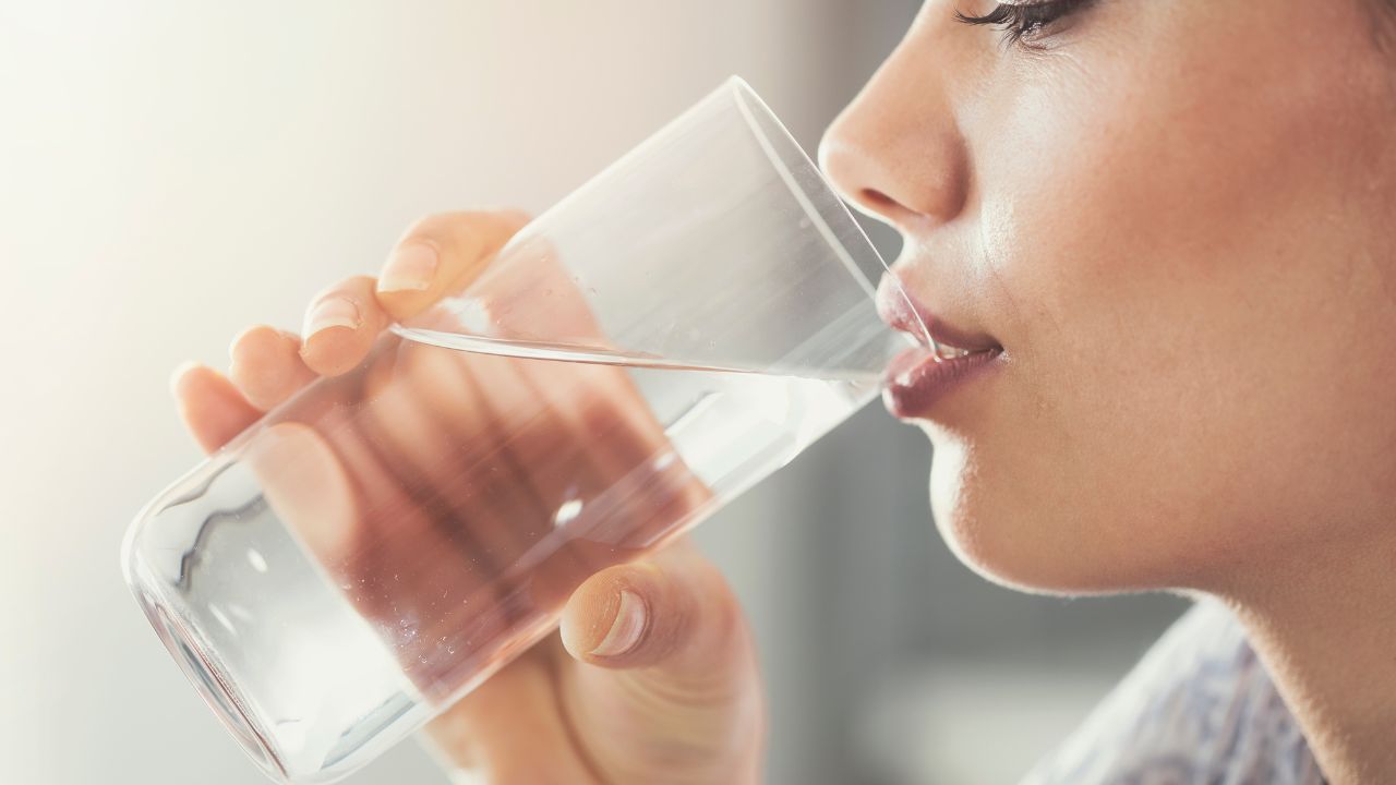 Persona bebiendo agua de un vaso