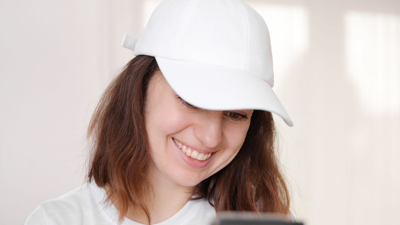 Persona sonriendo con gorra blanca