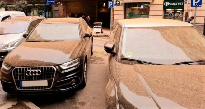 Coches cubiertos de polvo en la calle